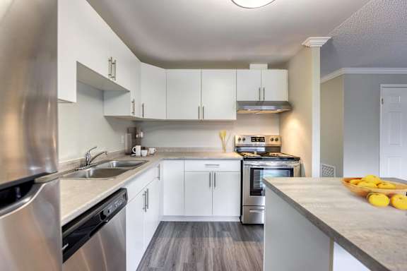 A modern kitchen with stainless steel appliances and white cabinets.