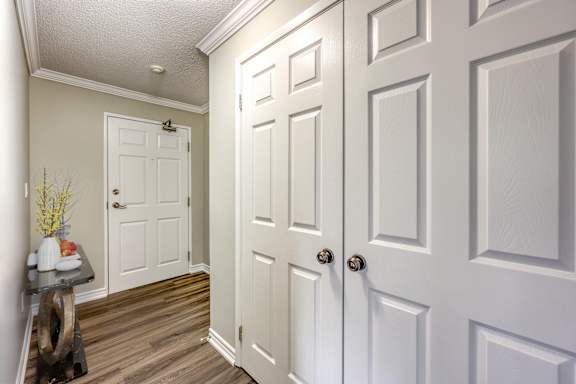 A hallway with white doors and a table with flowers on it.