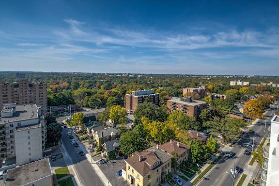 A cityscape with buildings and trees in autumn colors.