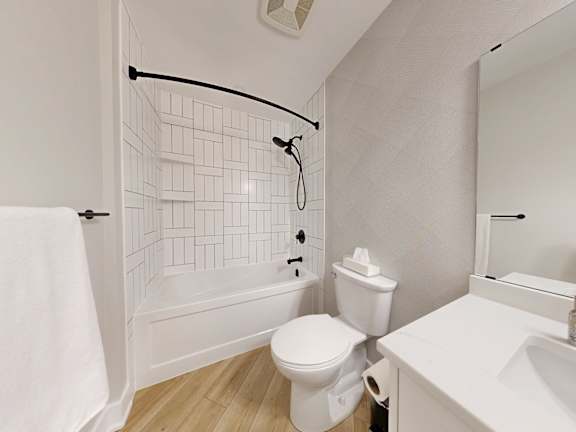 A white bathroom with a toilet, sink, and bathtub.