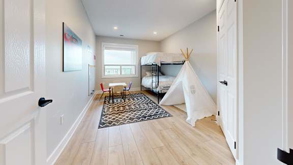 A room with a teepee and a rug in the middle.