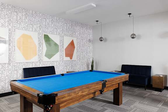 A pool table in a room with a patterned wallpaper at 1600 Hyde Park Village Apartments, London