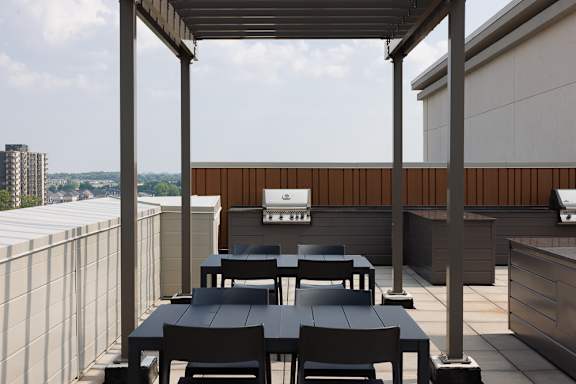 A patio with tables and chairs under a roof.