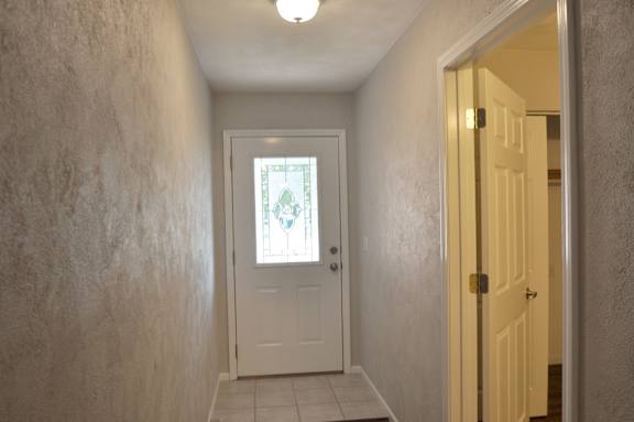 A hallway with a white door and a light on.