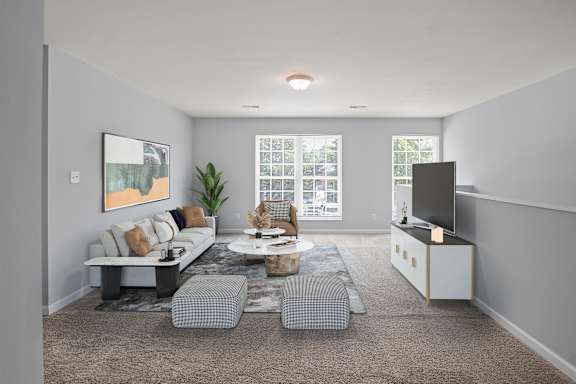 A modern living room with a grey sofa, a coffee table, and a flat screen TV.