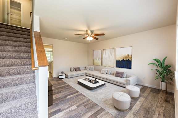 A living room with a staircase on the left side.