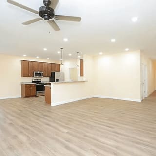 A spacious kitchen with a fan on the ceiling.