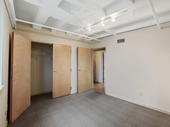 an empty room with a carpeted floor and wooden doors