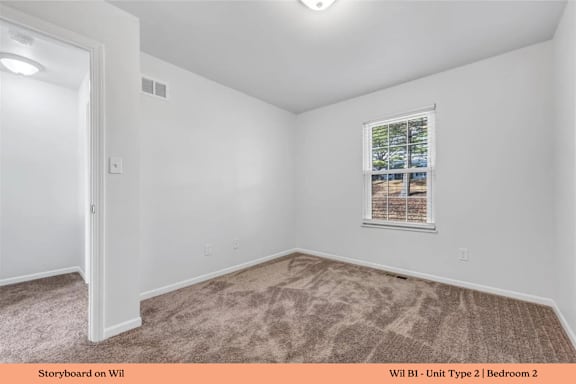 A bedroom with a carpeted floor and a window with blinds.