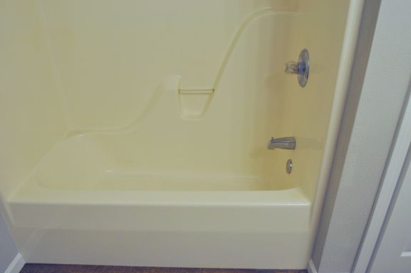 A white bathtub with a silver faucet and handle.