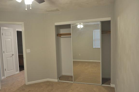 A room with a sliding door and a ceiling fan.