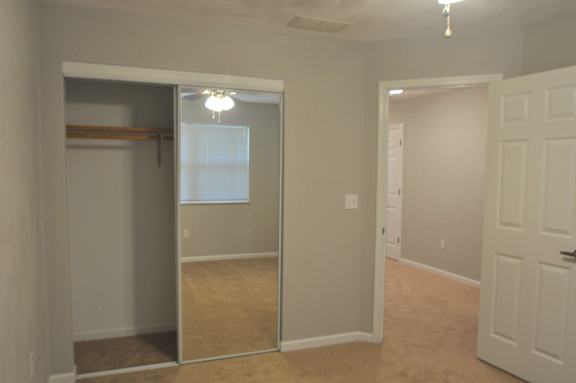 A room with a white door and a closet with a sliding door.