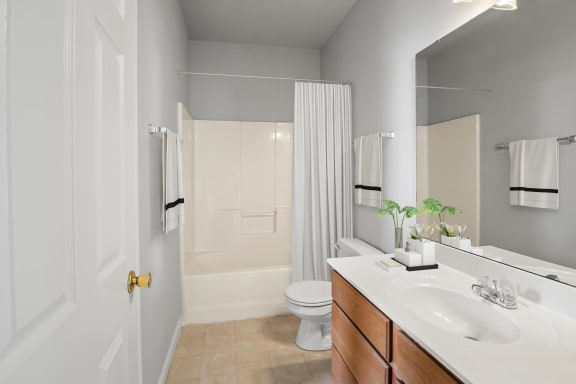 a bathroom with a white toilet next to a white sink with a mirror above it