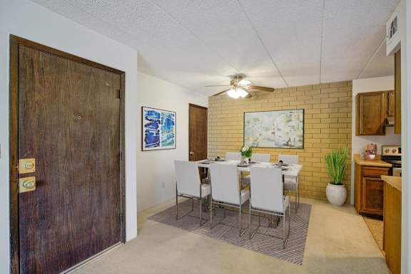 A dining room with a wooden table and chairs.