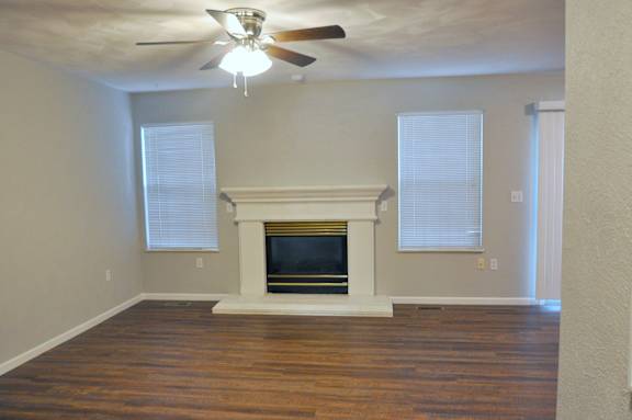 A room with a fireplace and a ceiling fan.