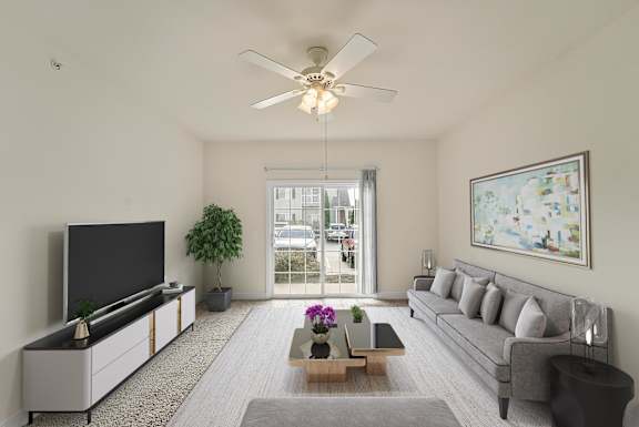 a living room with a gray couch and a ceiling fan
