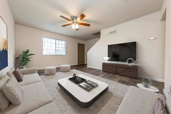 A living room with a grey sofa and a television on a cabinet.