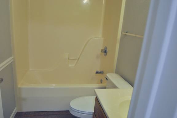 A white toilet sits next to a bathtub in a bathroom.