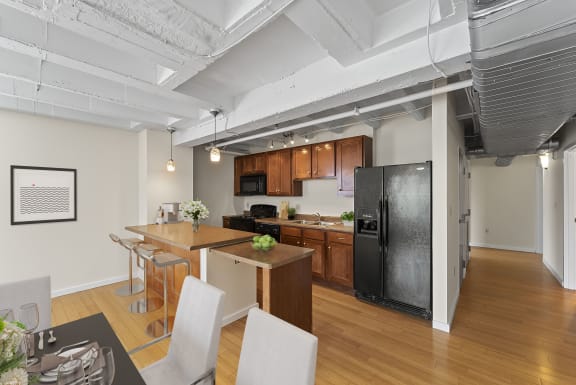 an open kitchen and dining area with a black refrigerator