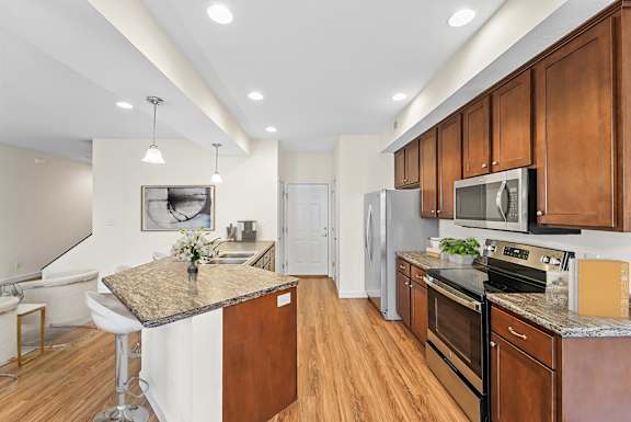 A kitchen with wooden cabinets and a granite countertop.