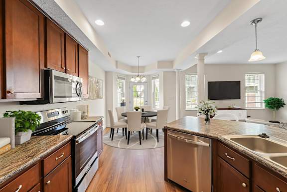 A kitchen with wooden cabinets and a dining table.