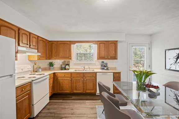 A kitchen with wooden cabinets and a white refrigerator.