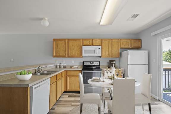 A kitchen with a table and chairs.