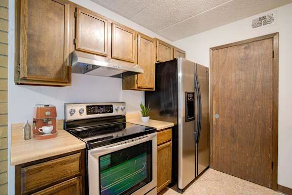 A kitchen with a stove, oven, and refrigerator.