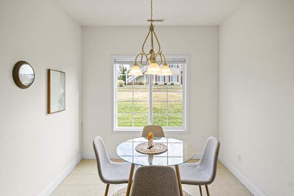 A dining room with a glass table and chairs.