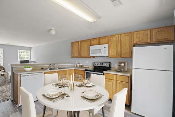 A modern kitchen with a dining table set for two.