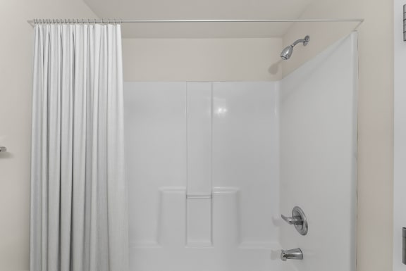 a white shower with a shower curtain in a bathroom
