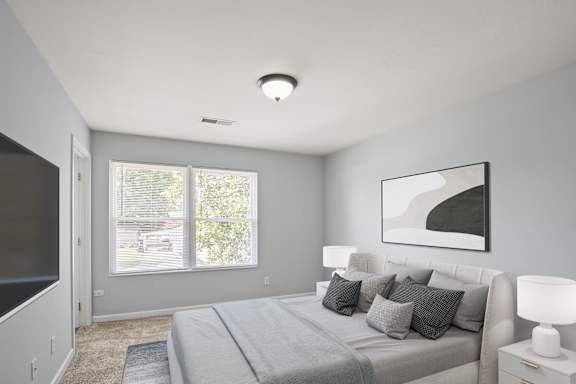 A bedroom with a large bed and a painting on the wall.