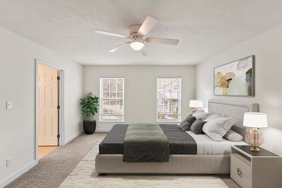A bedroom with a bed, nightstand, and a ceiling fan.