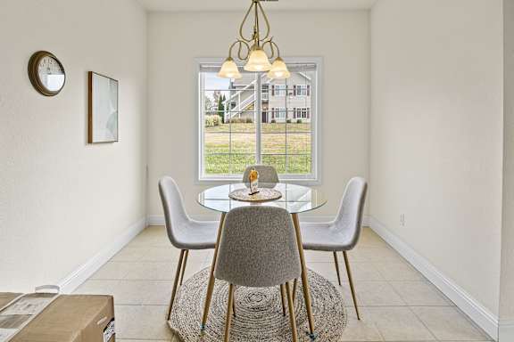 A dining room with a table and chairs.