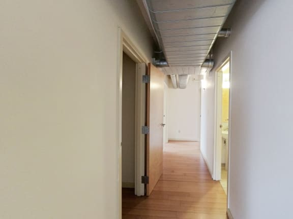 a hallway with white walls and a wood floor