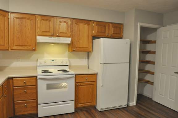 A kitchen with wooden cabinets and a white refrigerator.