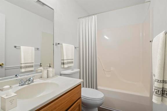 A bathroom with a sink, toilet, and shower.