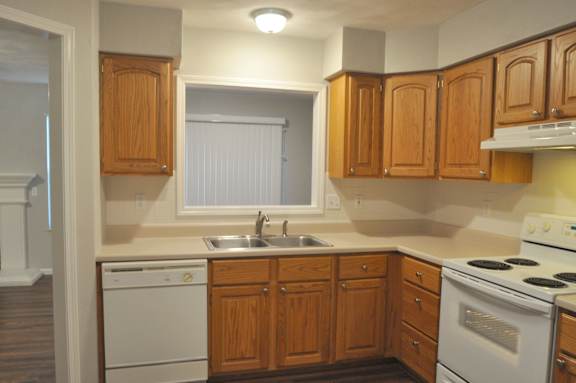 A kitchen with wooden cabinets and white appliances.