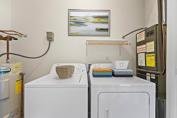 a laundry room with two washing machines and a painting on the wall