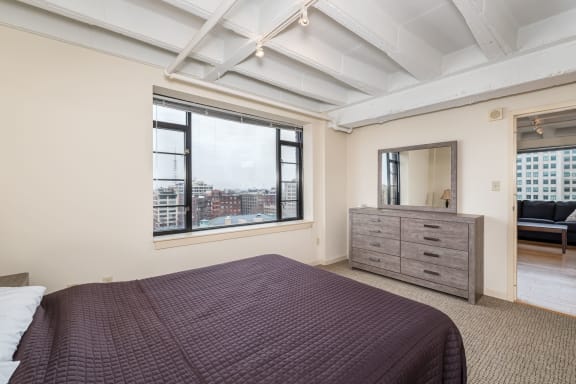 a bedroom with a bed and a large window