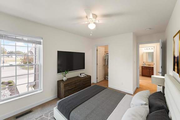 A bedroom with a large bed and a flat screen TV mounted on the wall.