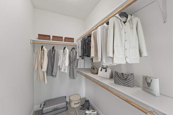 a walk in closet with shelves and racks of clothes and bags