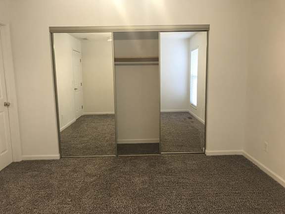A large mirror in a room with carpeted floor.