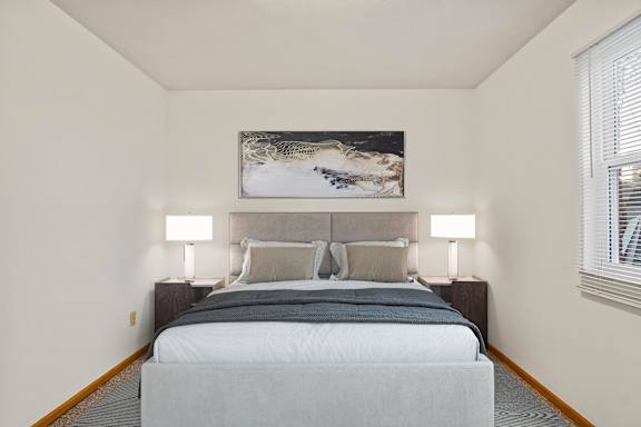 A bedroom with a large bed and a painting above it.