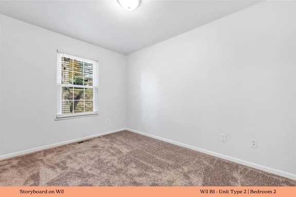 A bedroom with a carpeted floor and a window with blinds.