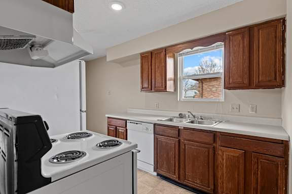 A kitchen with a white stove and brown cabinets.