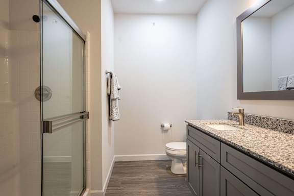A bathroom with a toilet, sink, and shower.
