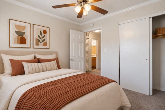 A bedroom with a large bed and a ceiling fan.