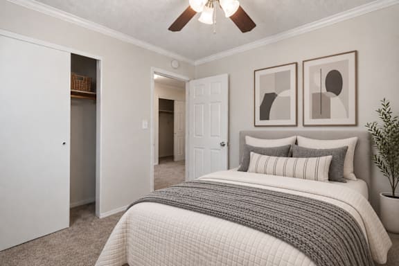 A bedroom with a large bed and two pictures on the wall.