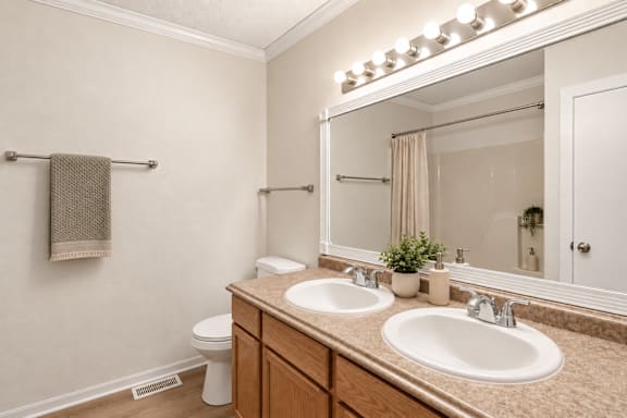 A bathroom with a towel hanging on the wall and a mirror above the sink.